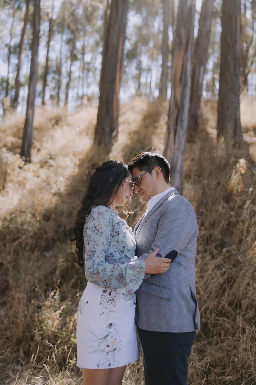 Cesar y Carmen compartiendo un beso entre árboles
